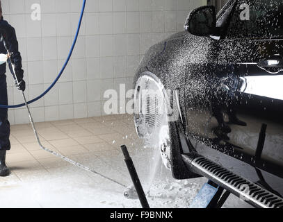 Service de voiture. Laver le travailleur de la voiture sous une haute pression. Banque D'Images