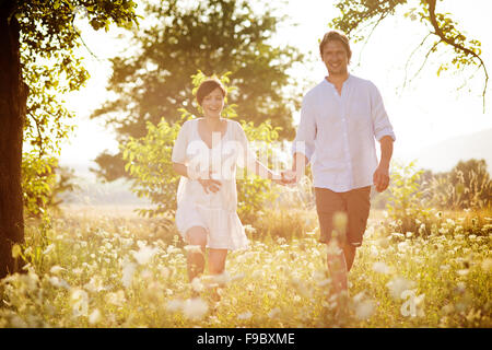 Professionnels et jeunes femmes enceintes couple hugging in nature Banque D'Images