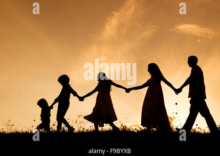 Silhouettes d'heureux parents d'avoir du plaisir avec leurs enfants Banque D'Images