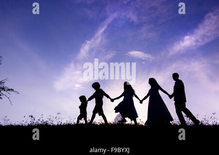 Silhouettes d'heureux parents d'avoir du plaisir avec leurs enfants Banque D'Images