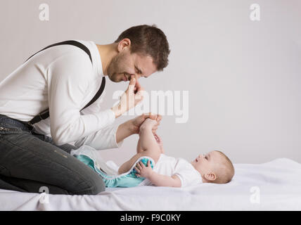 Young attractive père change nappy à son baby girl Banque D'Images