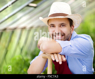 Jeune homme dans la serre de jardinier Banque D'Images