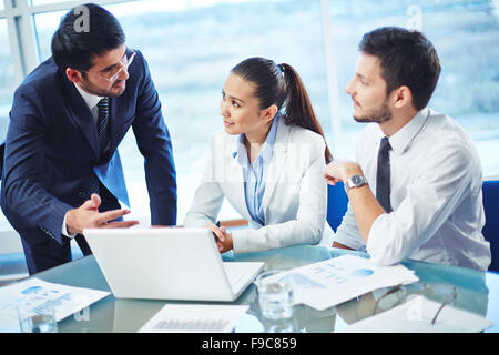 Les gens d'affaires travailler ensemble sur leur laptop at office Banque D'Images