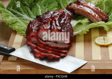 La cuisine cantonaise Char siu littéralement "fork-roast' sur une planche à découper Banque D'Images