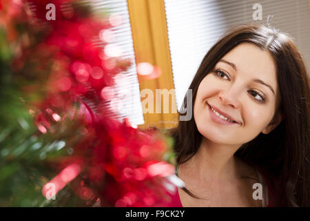 Belle jeune femme est la décoration de sapin de Noël. Banque D'Images