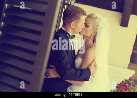 Bride and Groom kissing fenêtre proche Banque D'Images