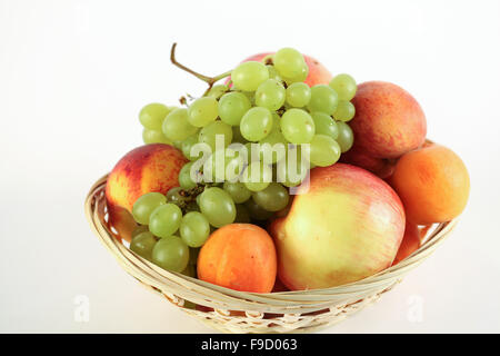 Panier de pêche et abricot pomme raisin sur fond blanc Banque D'Images