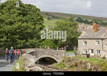 Les marcheurs dans le village de Swaledale Thwaite, Yorkshire Dales National Park, Richmondshire, North Yorkshire, England, UK Banque D'Images