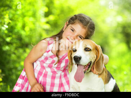 Cute little girl joue avec son chien dans le green park Banque D'Images