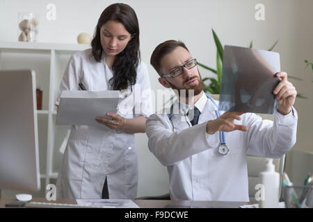 Doctors discussing intestins xray at medical office Banque D'Images