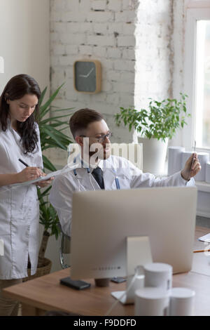 Doctors discussing intestins xray at medical office Banque D'Images