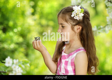 Petite fille joue avec papillon dans la nature Banque D'Images