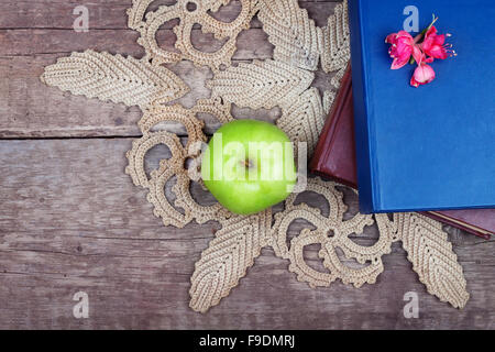 Pile de livres et de pomme verte sur table en bois vintage Banque D'Images