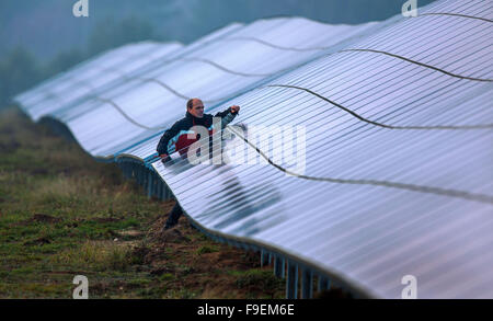 Gestionnaire de projet Klaus Schrot vérifie la dernière des panneaux solaires avant l'ouverture d'une nouvelle ferme solaire sur un ancien champ de tir dans Star Buchholz à Schwerin, Allemagne, 16 décembre 2015. La société PVStrom a installé près de 40 000 modules solaires onb les motifs de l'Institut pour l'immobilier fédéral (Bundesanstalt für Immobilienaufgaben). L'installation va donc générer plus de 10 000 mégawattheures d'énergie solaire par an. Environ 9 millions d'euros ont été investis dans le parc solaire. Photo : JENS BUETTNER/dpa Banque D'Images