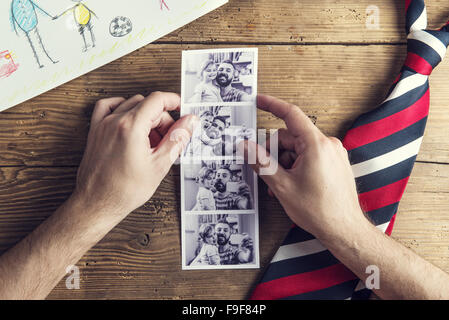 Photos Polaroid de père et fille, childs le dessin et tie posé sur un bureau en bois. fond Banque D'Images