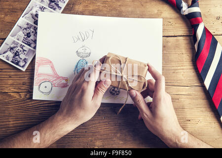 Photos Polaroid de père et fille, dessin d'enfant, du présent et de l'égalité mis sur fond d'un bureau en bois. Banque D'Images