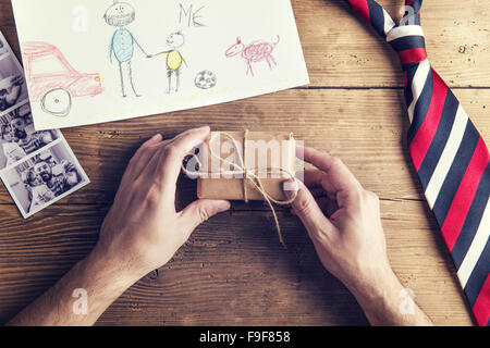 Photos Polaroid de père et fille, dessin d'enfant, du présent et de l'égalité mis sur fond d'un bureau en bois. Banque D'Images