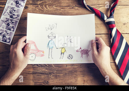 Photos Polaroid de père et fille, childs le dessin et tie posé sur un bureau en bois. fond Banque D'Images