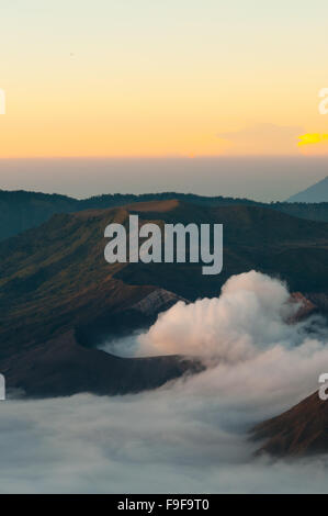 Bromo volcan de fumée, le brouillard et la bruine tôt le matin au lever du soleil Banque D'Images