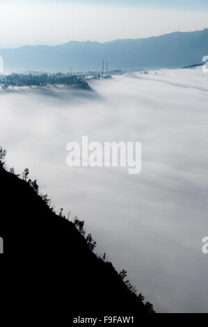 La montagne noire raide silhouette devant un épais brouillard Sheet Banque D'Images