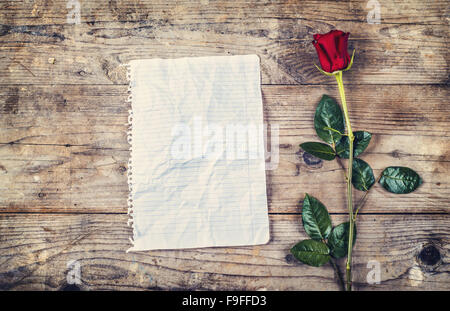 Saint-valentin composition de feuille de papier froissé ou vierge lettre d'amour et de rose rouge. Studio shot sur un sol en bois backgroun Banque D'Images