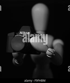 Artiste mannequin de bois tenant un appareil photo Nikon Banque D'Images