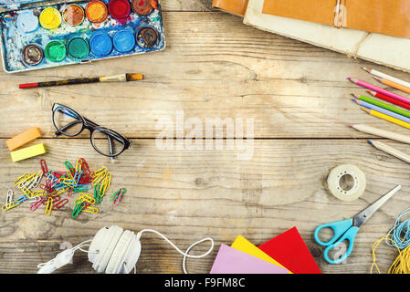 24 d'un artiste avec beaucoup d'objets de papeterie. Studio shot sur fond de bois. Banque D'Images