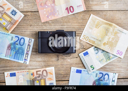 Ancien appareil photo et des billets de banque sur fond d'un bureau en bois. Banque D'Images