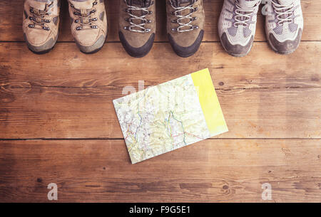 Des chaussures de randonnée et la carte posée sur un plancher en bois historique Banque D'Images