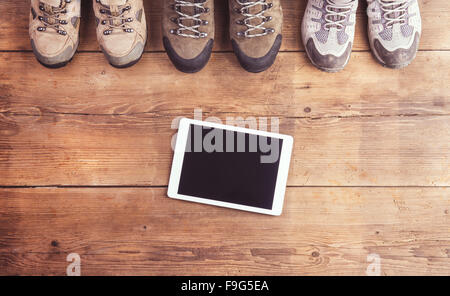 Des chaussures de randonnée et tablette posée sur un plancher en bois historique Banque D'Images
