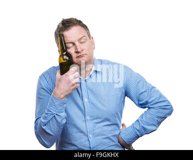 Drôle jeune homme ivre tenant une bouteille de bière. Studio shot sur fond blanc. Banque D'Images