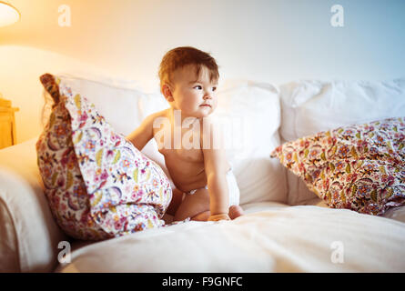 Cute little baby le jeu et le plaisir sur un canapé Banque D'Images