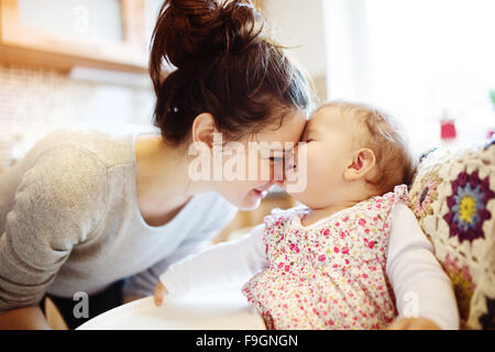 Jeune mère et sa petite fille prenant le petit déjeuner avec eux Banque D'Images