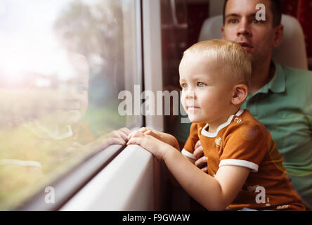 Le père avec son fils sur ses genoux voyager en train. Banque D'Images