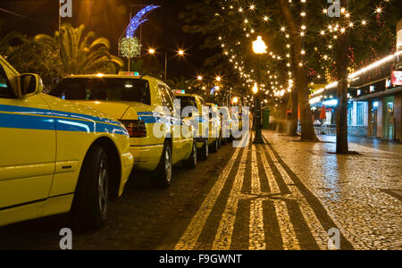 Les taxis jaunes en attente dans la nuit dans l'île de Madère, Funchal, Portugal Banque D'Images