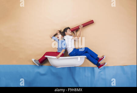 Enfants joyeux comme marins sur la mer. Studio shot sur un fond beige. Banque D'Images