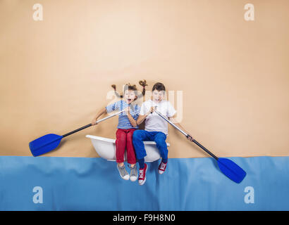 Enfants joyeux comme marins sur la mer. Studio shot sur un fond beige. Banque D'Images