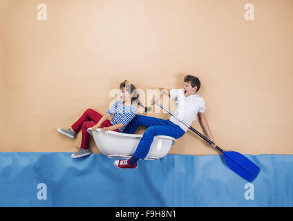 Enfants joyeux comme marins sur la mer. Studio shot sur un fond beige. Banque D'Images