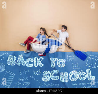 Schoolkids joyeux comme marins sur la mer. Studio shot sur un fond beige. Banque D'Images