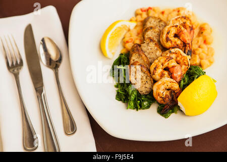 Crevettes grillées et poulet saucisse avec haricots verts et épinards sautés, Paradise Cafe, Santa Barbara, Californie Banque D'Images