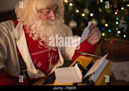Le Père Noël à la maison répondant aux lettres d'enfants Banque D'Images