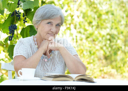 Middle-aged woman reading book Banque D'Images