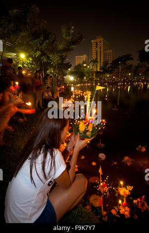 Jeune femme en prière bouddhiste, ce souhait tout en maintenant son krathong à côté de Lumpini Park Lake au cours de Thai Loi Krathong Festival Banque D'Images