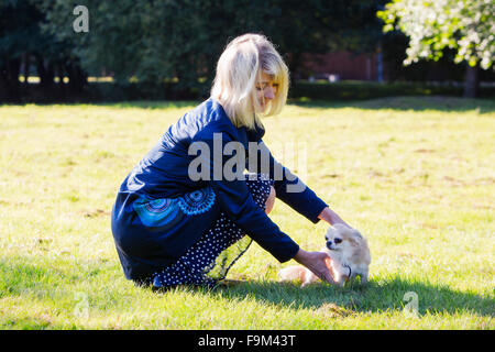 Femme blonde en prenant soin après le chien Banque D'Images