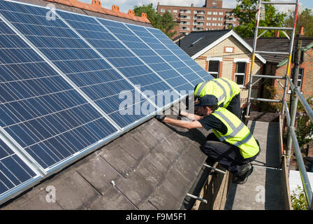 Installer les panneaux solaires photovoltaïques sur le toit d'ardoise d'une maison victorienne à Londres, en Angleterre. Banque D'Images