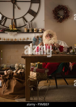 Travailler à la maison du Père Noël. La réparation de ses gants Banque D'Images