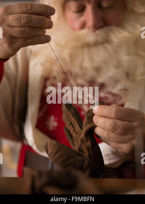 Travailler à la maison du Père Noël. La réparation de ses gants Banque D'Images