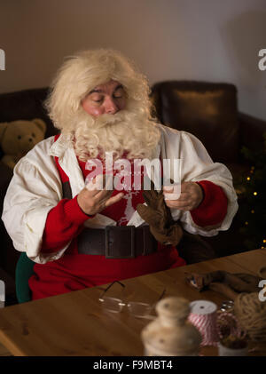 Travailler à la maison du Père Noël. La réparation de ses gants Banque D'Images