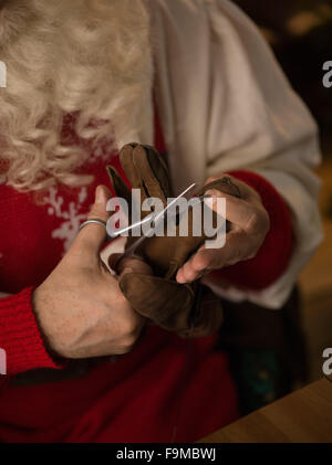 Travailler à la maison du Père Noël. La réparation de ses gants Banque D'Images