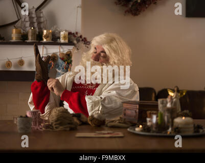 Travailler à la maison du Père Noël. La réparation de ses gants Banque D'Images